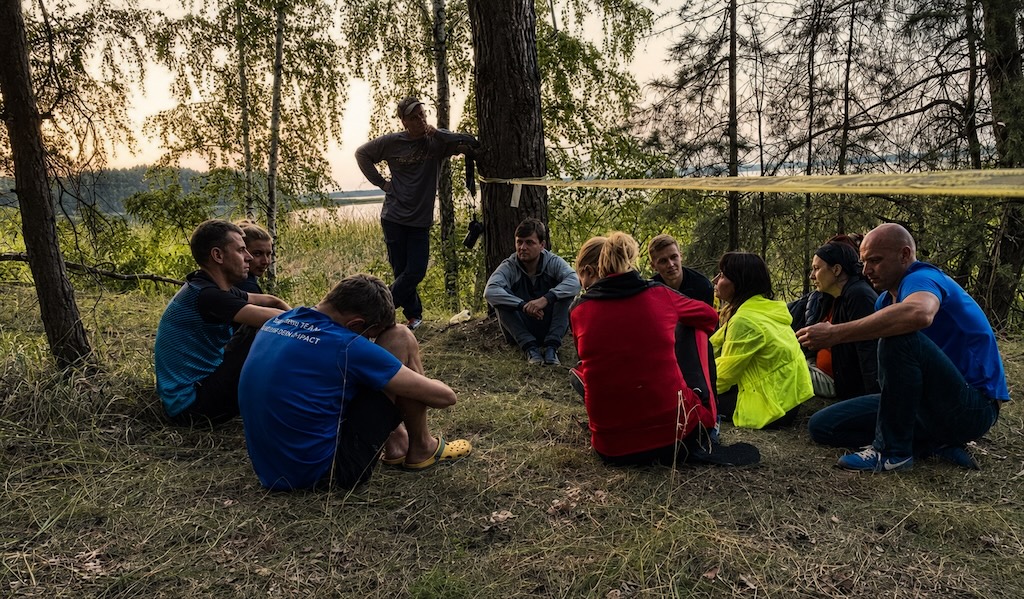 Small group debriefing by the lake