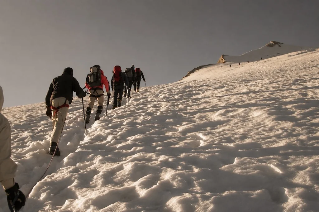 Group ascending a snow-covered mountain